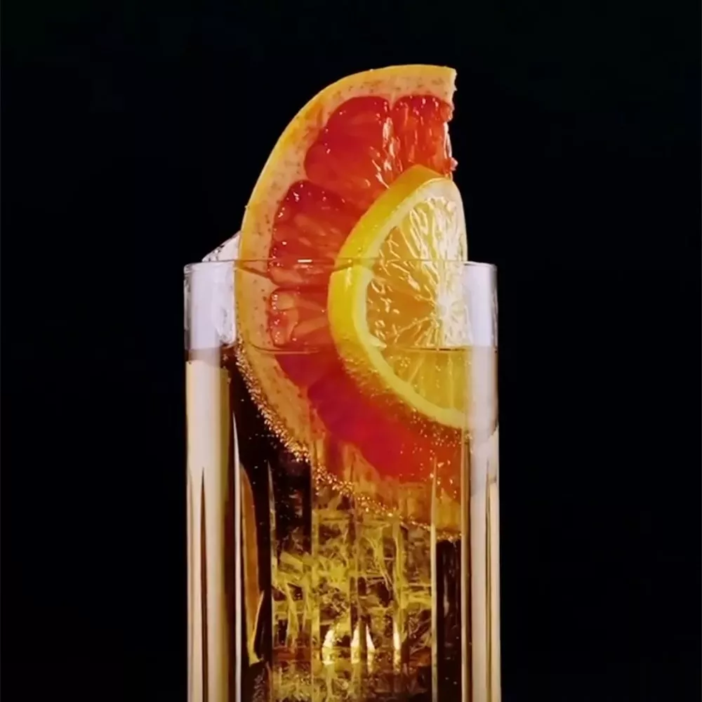 Clear glass of cognac garnished with grapefruit and lime slices