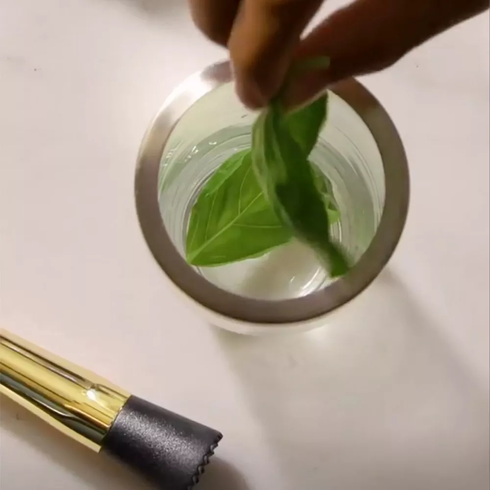 Muddling mint leaves for a cognac cocktail